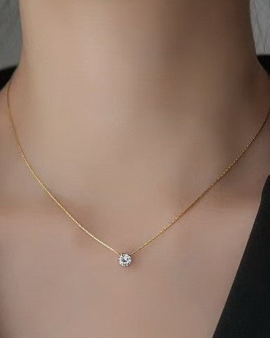 Gold necklace with a diamond pendant on a mannequin