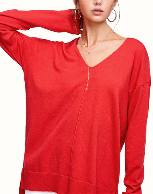 Woman wearing a red long-sleeve v-neck top on a white background.