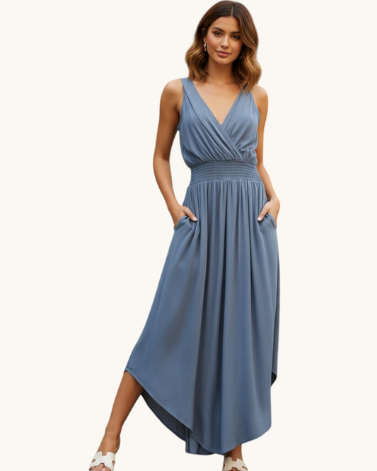 Woman wearing a slate blue jumpsuit on a white background.