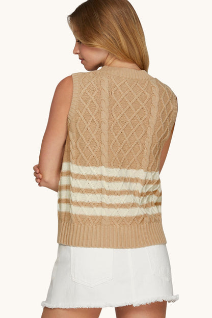 Back view of a woman wearing a sleeveless tan cable knit sweater with white stripes.