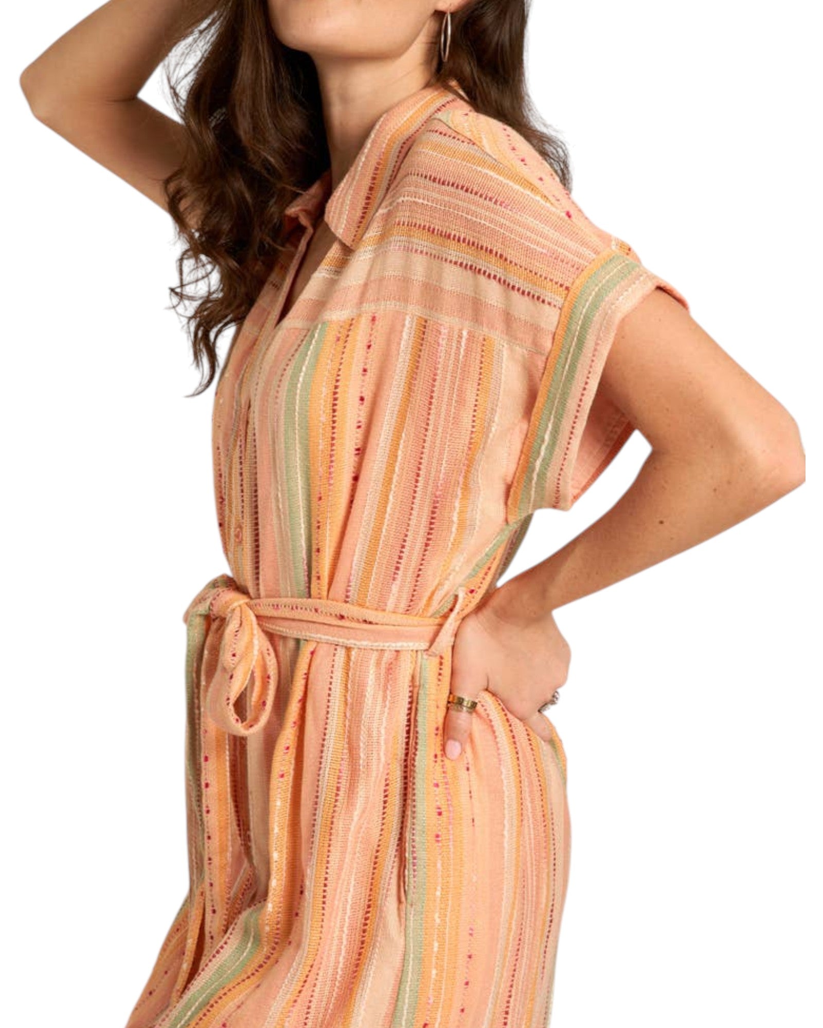 Woman wearing a peach-colored striped midi dress with a slit on a white background.