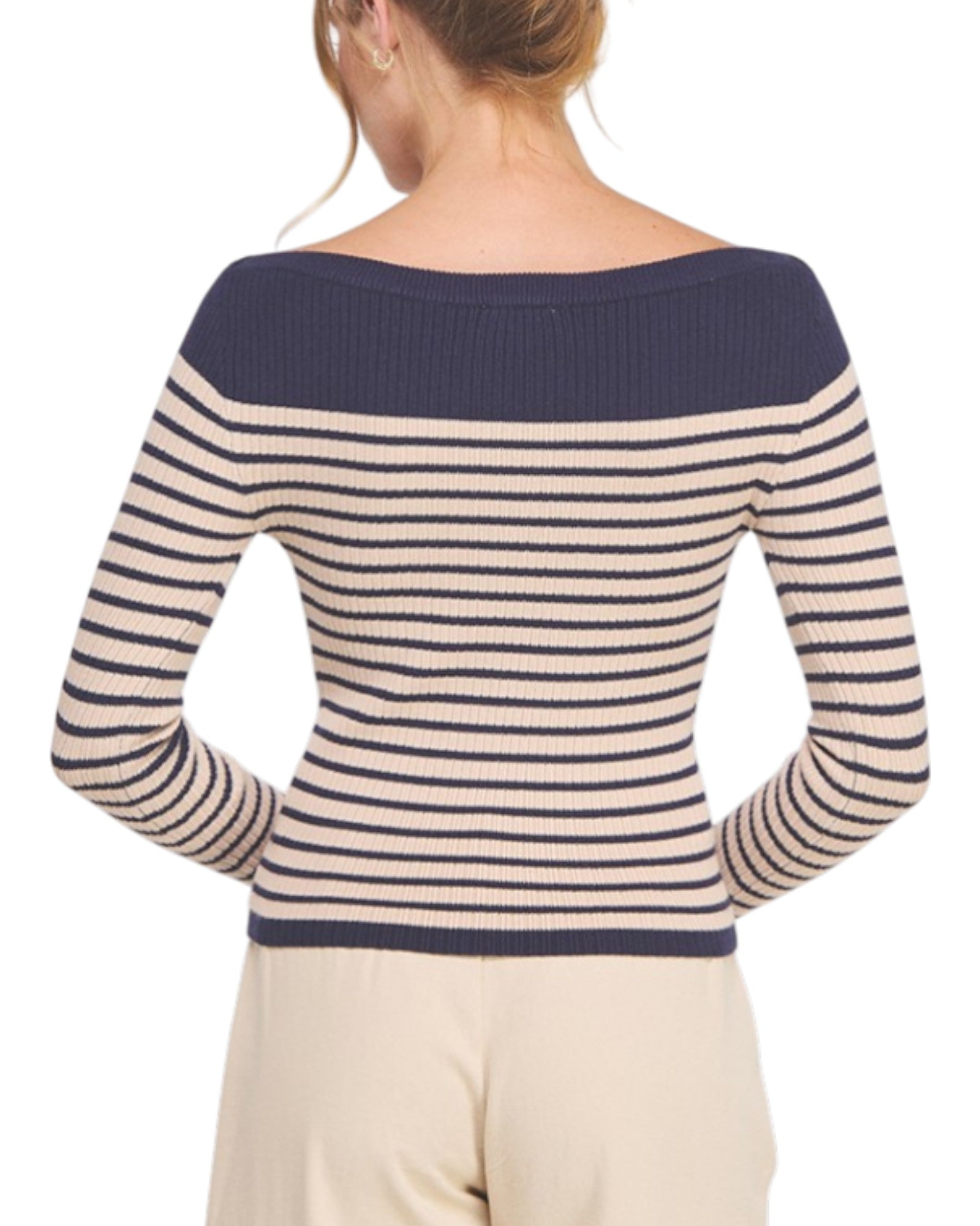 Woman wearing a striped sweater with navy and beige colors on a white background.