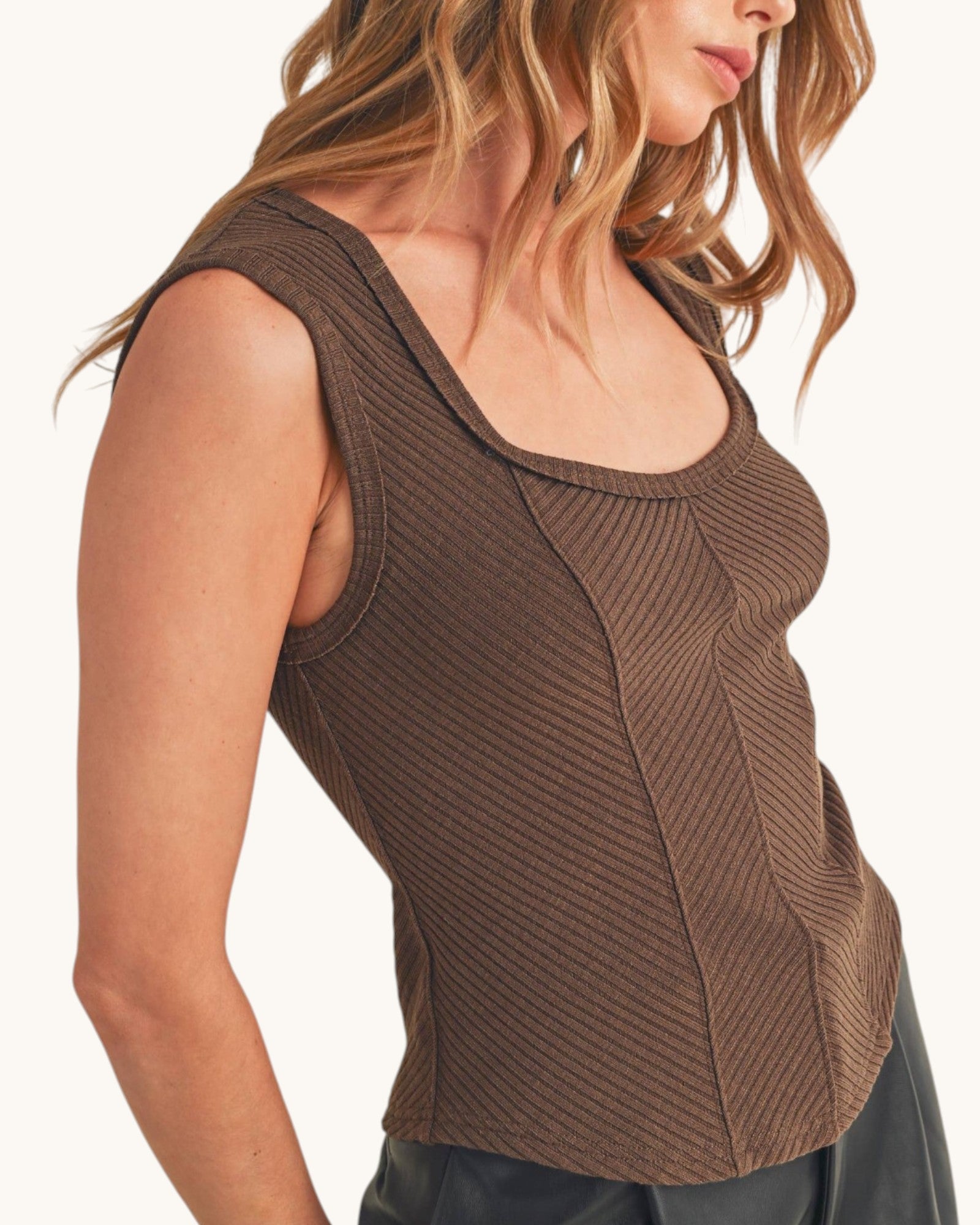 Woman wearing a ribbed sleeveless top with sweetheart neckline in chocolate color. 