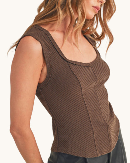 Woman wearing a ribbed sleeveless top with sweetheart neckline in chocolate color. 