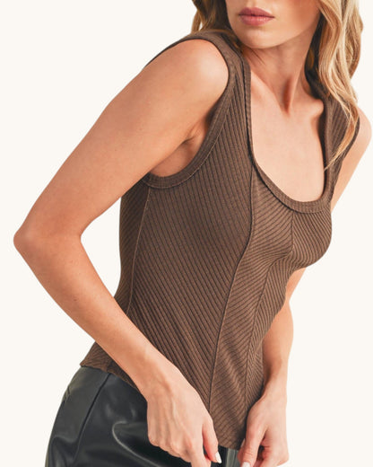Woman wearing a ribbed sleeveless top with sweetheart neckline in chocolate color. 