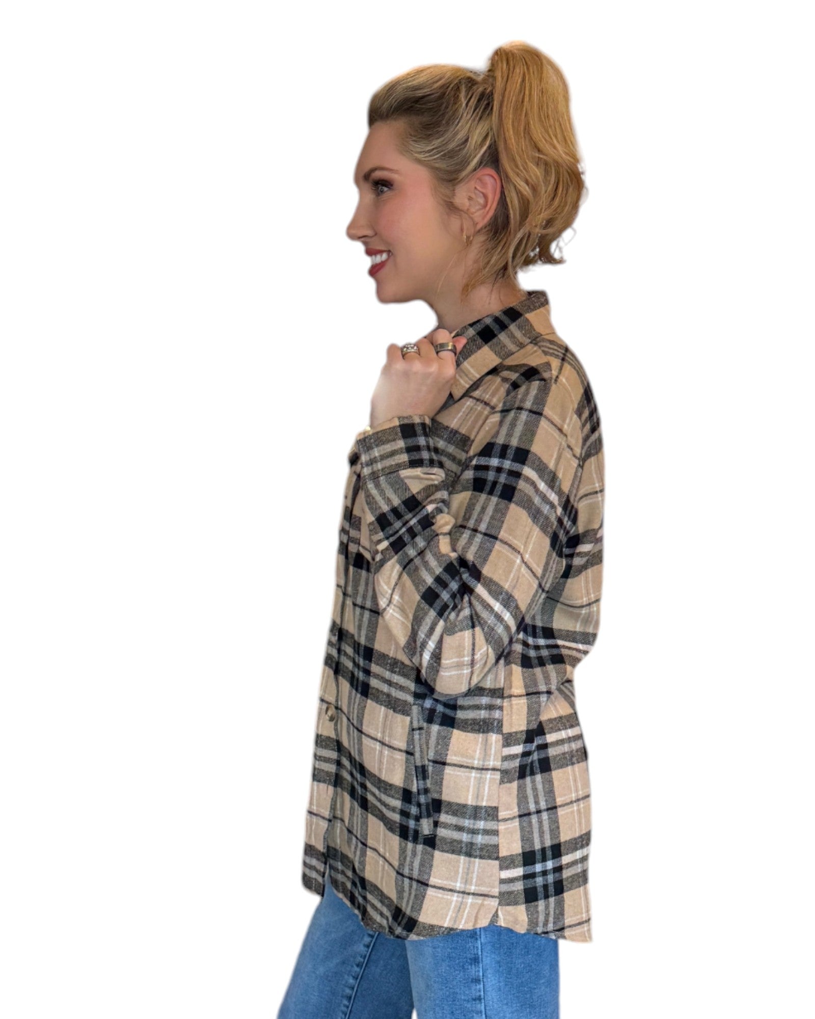 Woman wearing a tan and black plaid flannel and blue jeans.