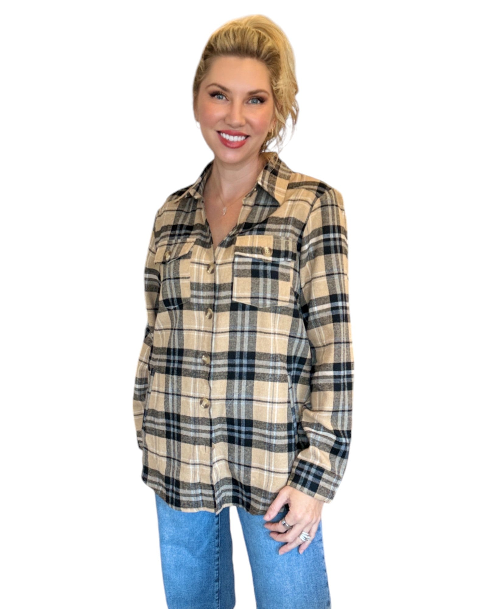 Woman wearing a tan and black plaid flannel and blue jeans.