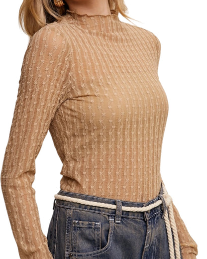 Woman wearing a tan semi-sheer long-sleeve top on a white background.