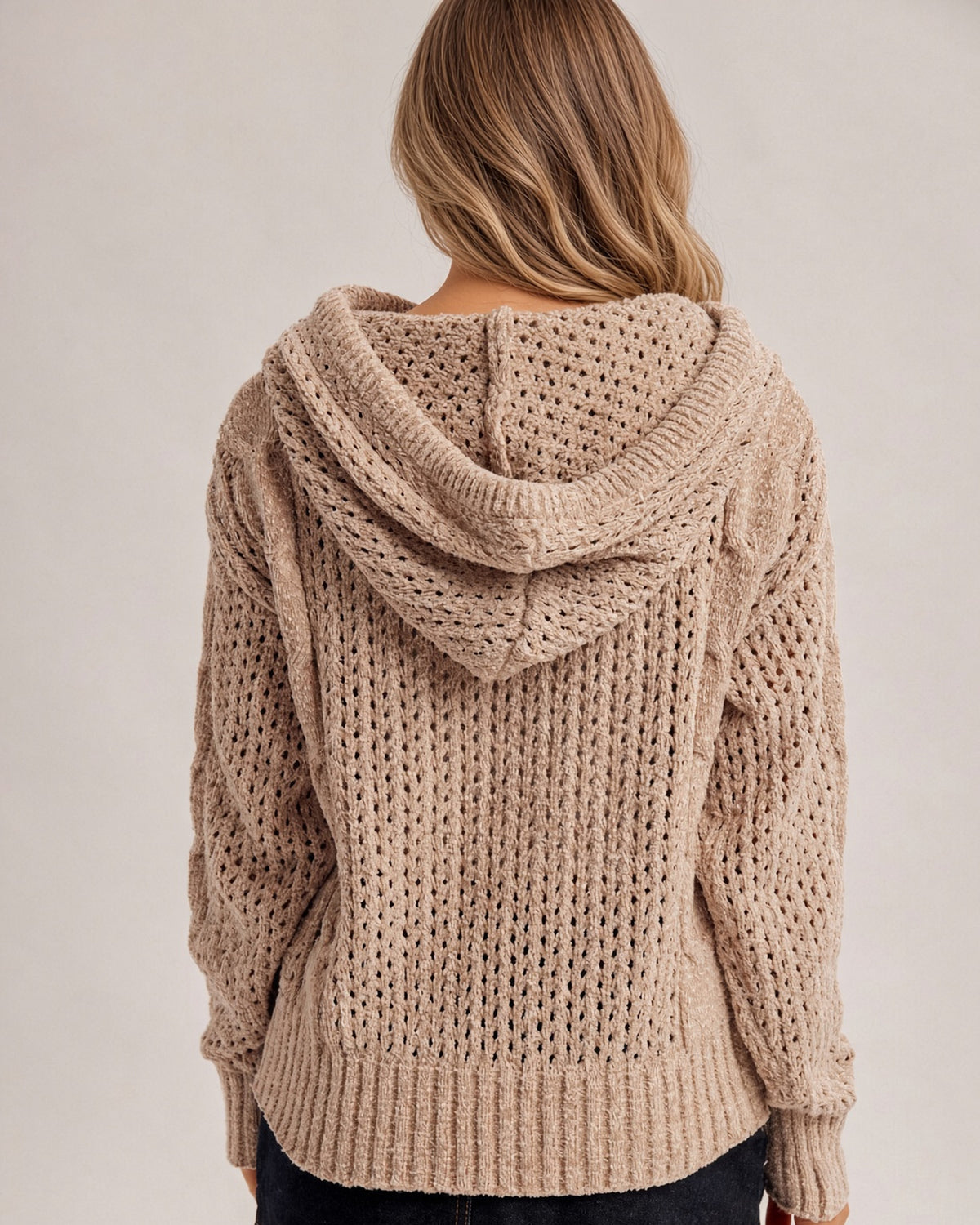 Back view of a woman wearing a pointelle speckled taupe stretchy hoodie sweater. 