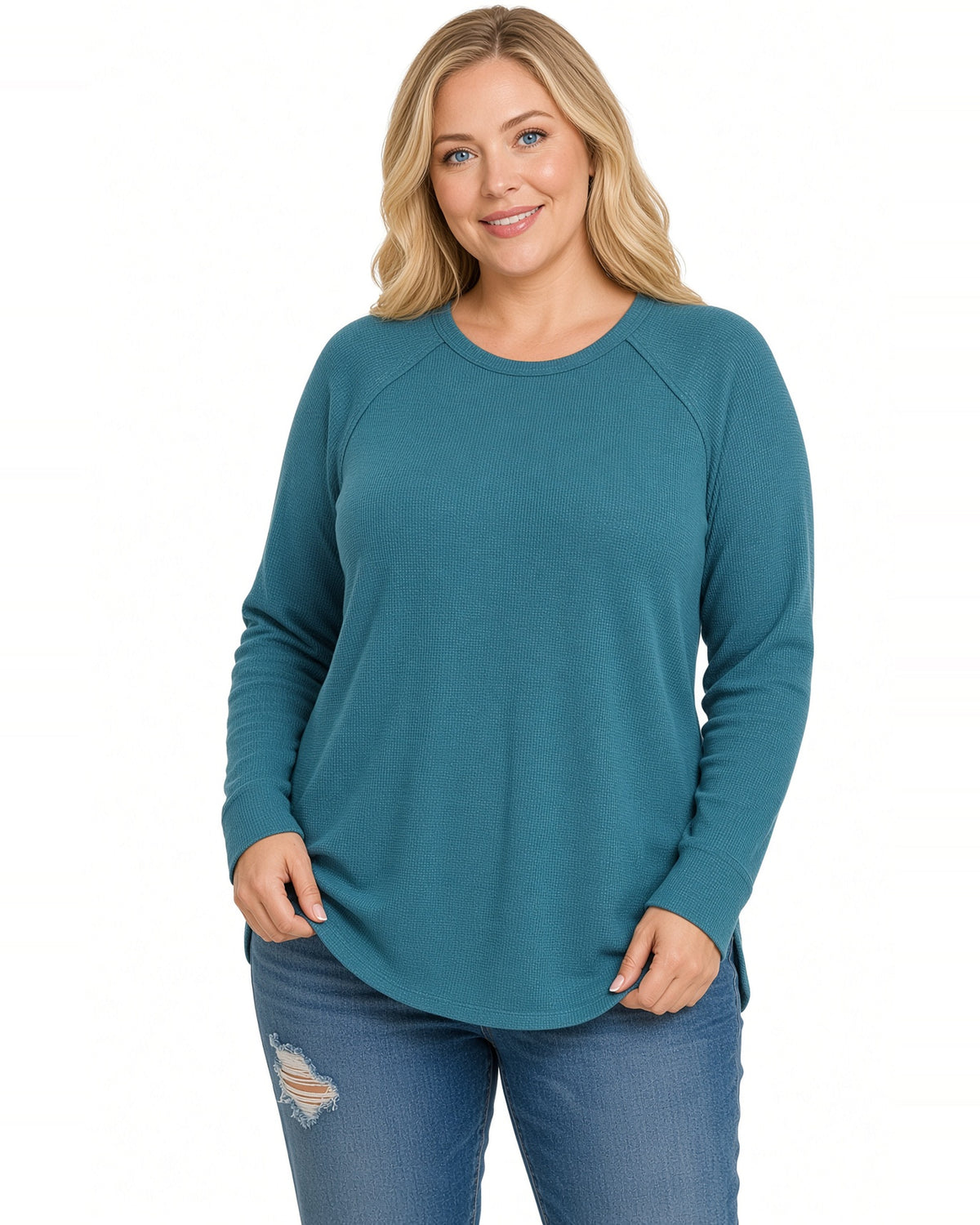Woman wearing a long sleeve ribbed crew neck top in teal with blue jeans.