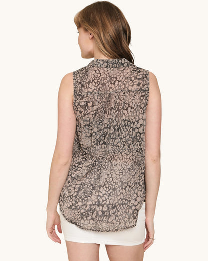 Woman wearing a sleeveless patterned top on a white background.