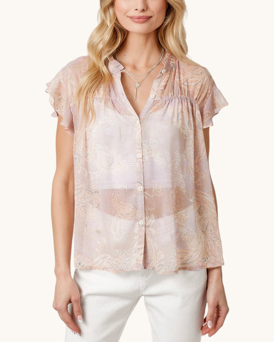 Woman wearing a sheer blush pink & paisley short sleeve button up with a white background.