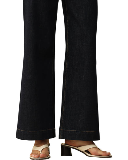 Dark blue jeans worn by a person on a white background.