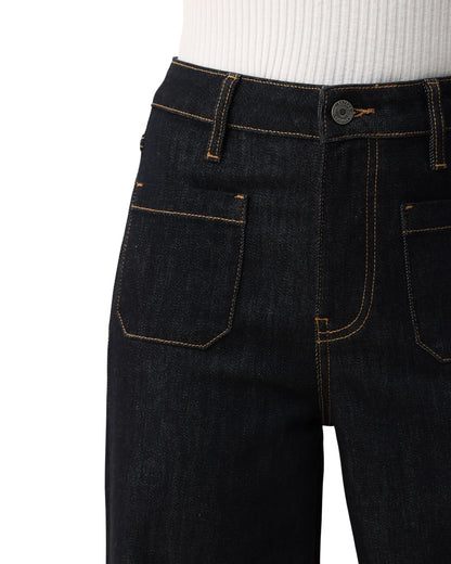 Person wearing dark blue wide-leg trouser-style jeans on a white background.