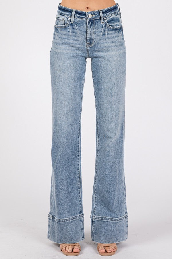 Close-up and full-length views of high-rise wider leg jeans with exaggerated trouser hem in a light/medium wash denim.