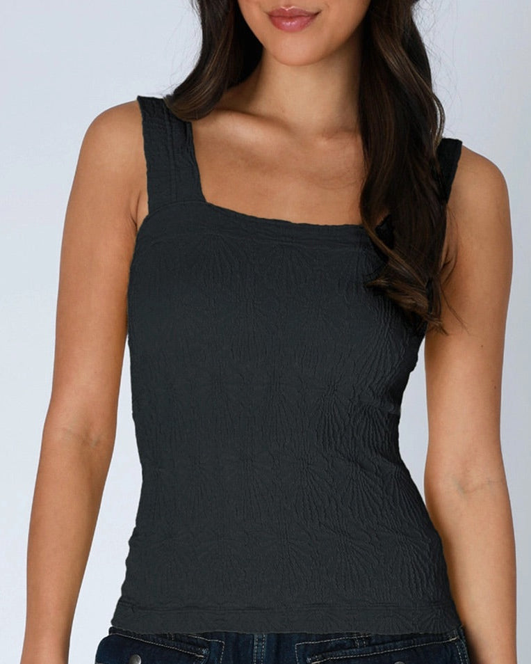 Woman wearing a black tank top against a plain background.