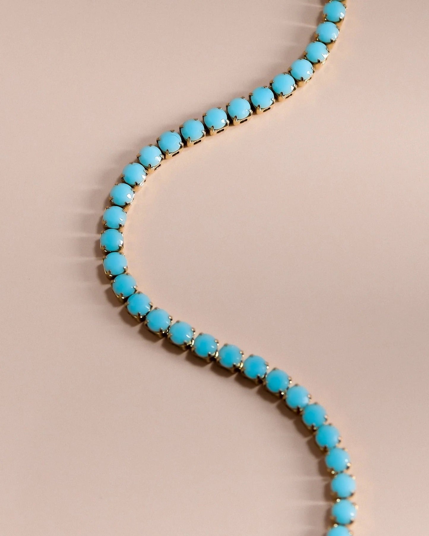 Turquoise rhinestone tennis chain necklace with gold finish and extender clasp.