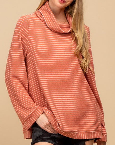 Woman wearing a striped sweater against a beige background