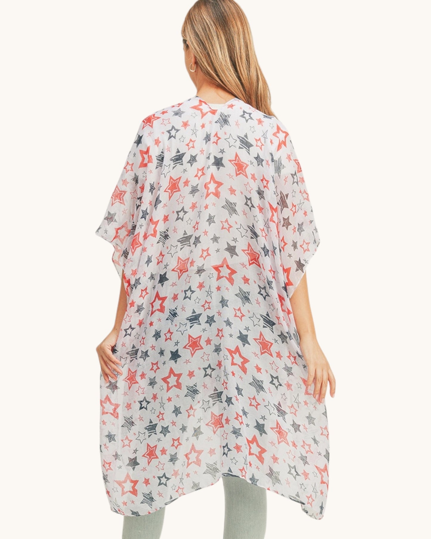 Back view of a woman wearing a star-patterned kimono-style garment over jeans on a white background.