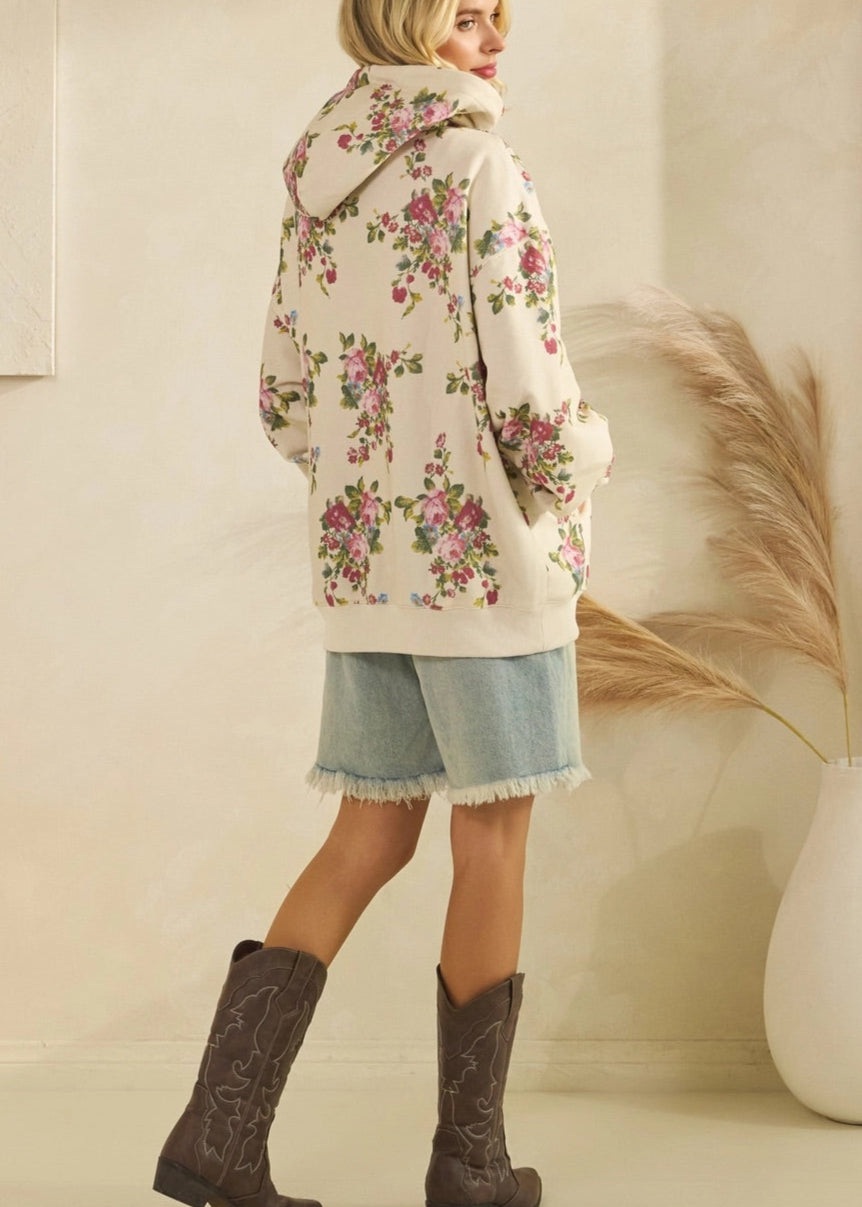 Woman wearing a floral coat and boots in a neutral setting