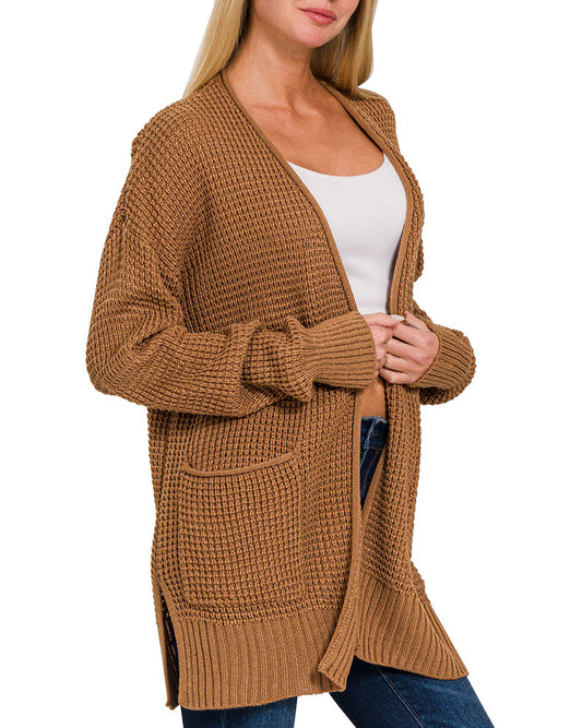 Woman wearing a deep camel waffle knit cardigan on a white background.