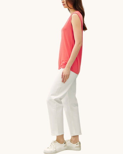 Side view of the Poppy Washed Scoop Neck Tank Top and cream denim pants and white sneakers.