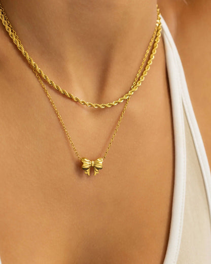 Gold waterproof bow charm necklace.