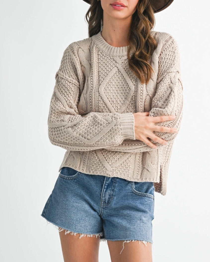 Wheat cable knit sweater with relaxed fit and chunky texture.