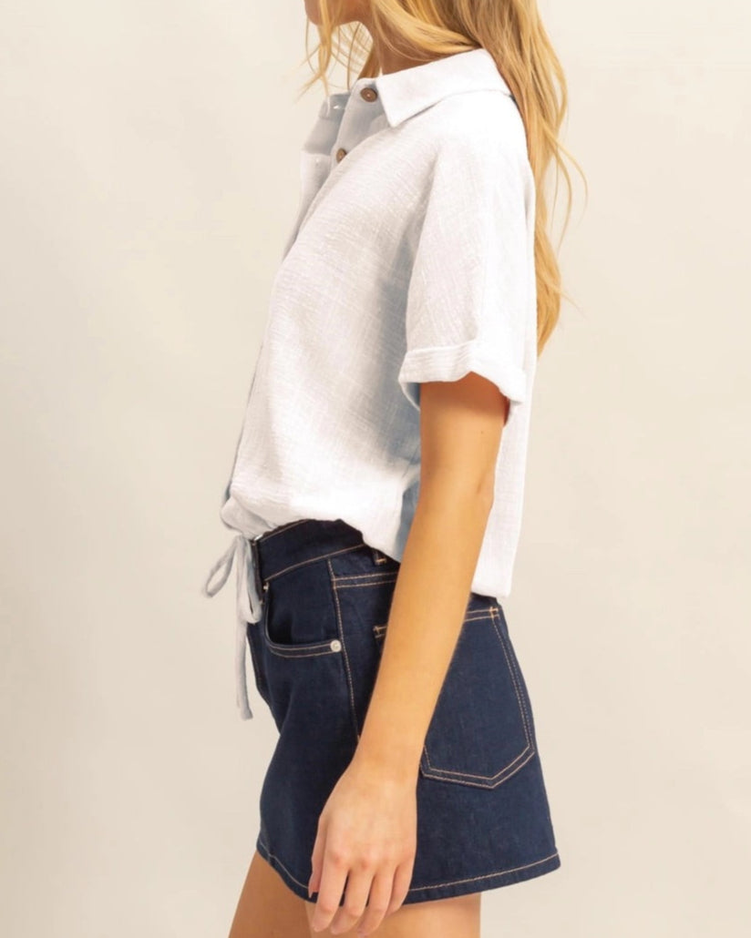 White short sleeve cotton button-up shirt with drawstring hem.