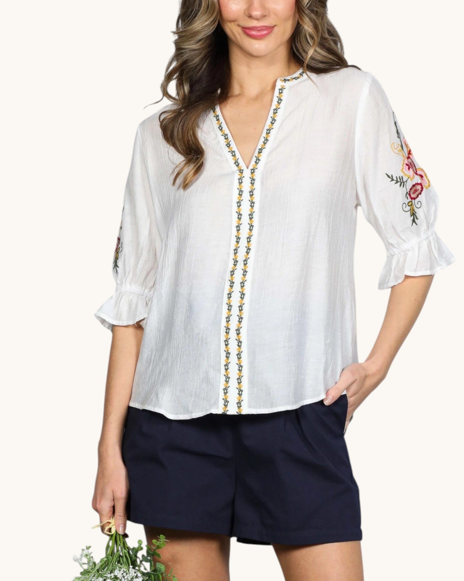 Flowy off-white embroidered top with ruffled balloon sleeves and curved hem, front view