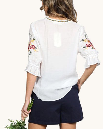 Lightweight semi-sheer off-white boho blouse with relaxed fit and hip-length curved hem, back view