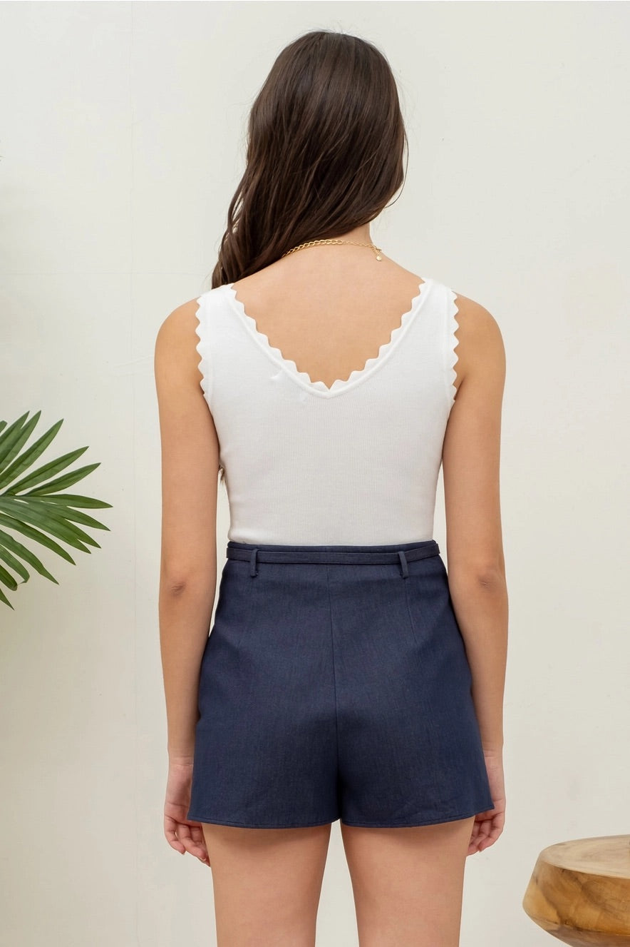 White tank top with flattering V-neckline, scalloped edges, and a stretchy knit fabric. 