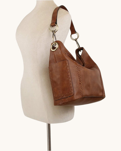 Brown leather hobo handbag with bronze hardware on a white background.