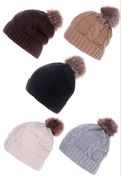 Set of five knit hats in different colors with pom-poms on a white background.