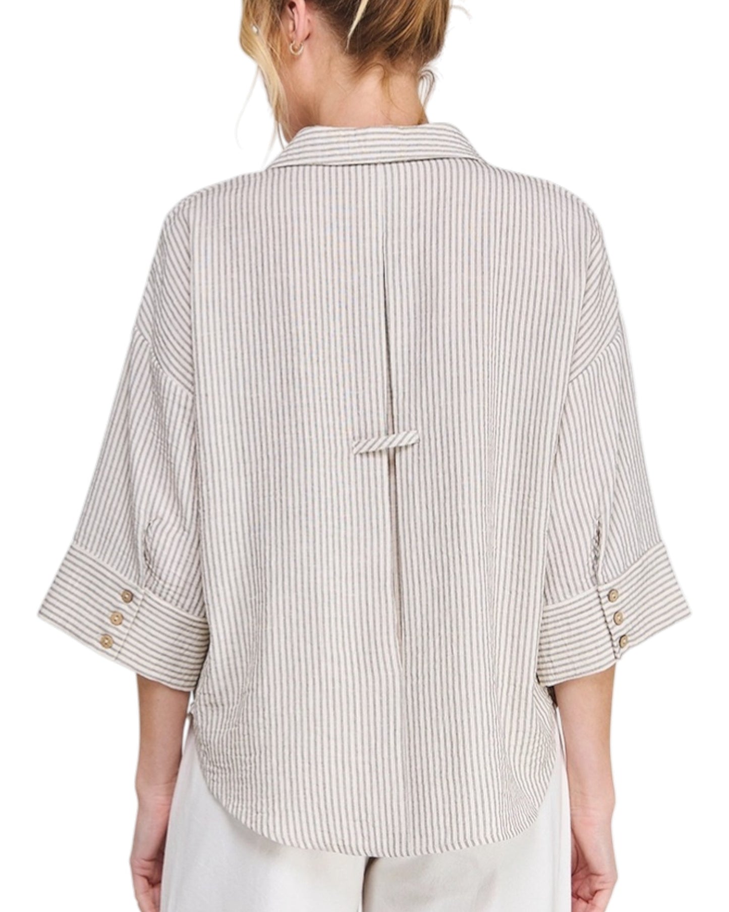 Woman wearing a striped shirt with 3/4 sleeves on a white background.