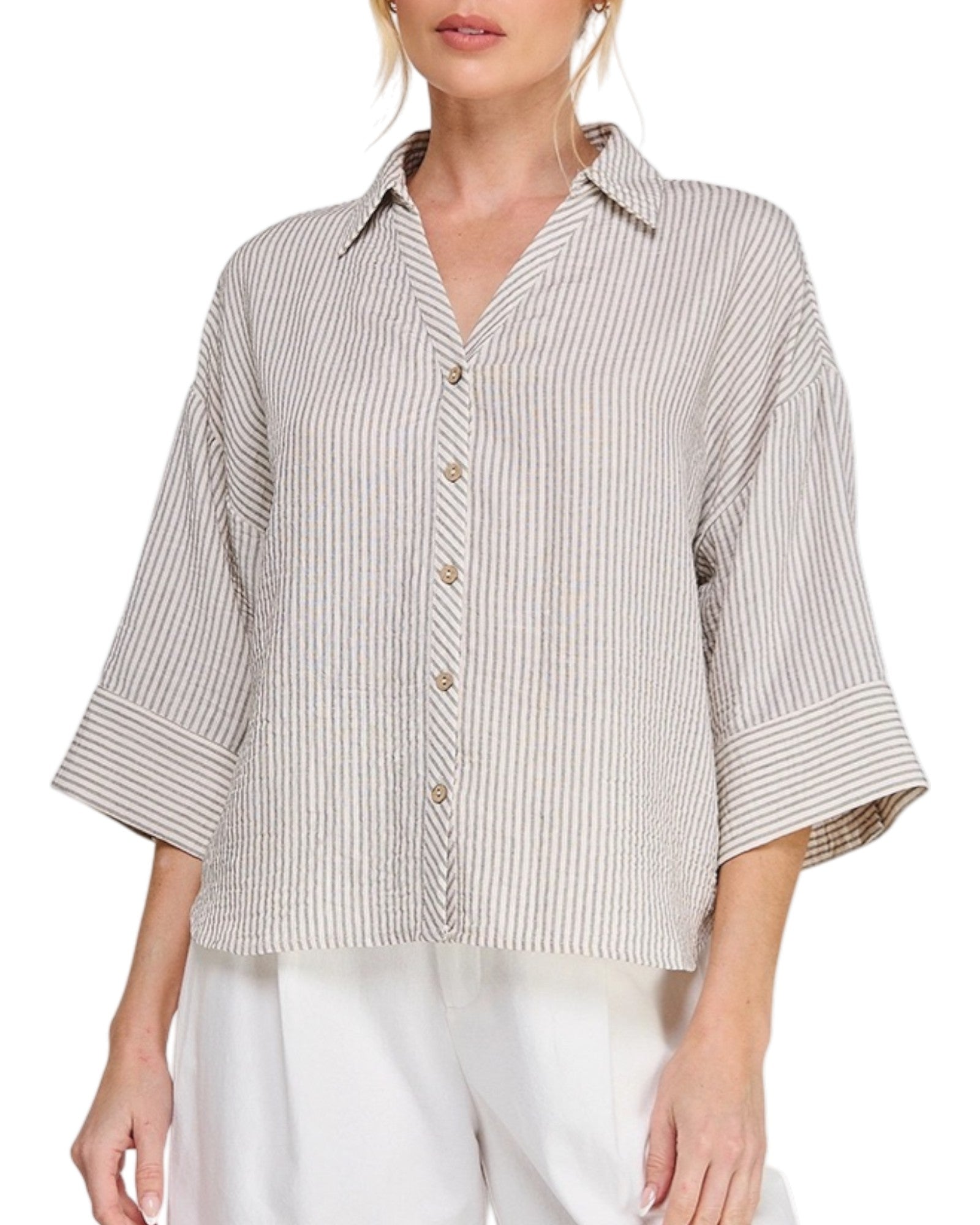 Woman wearing a striped shirt with 3/4 sleeves on a white background.