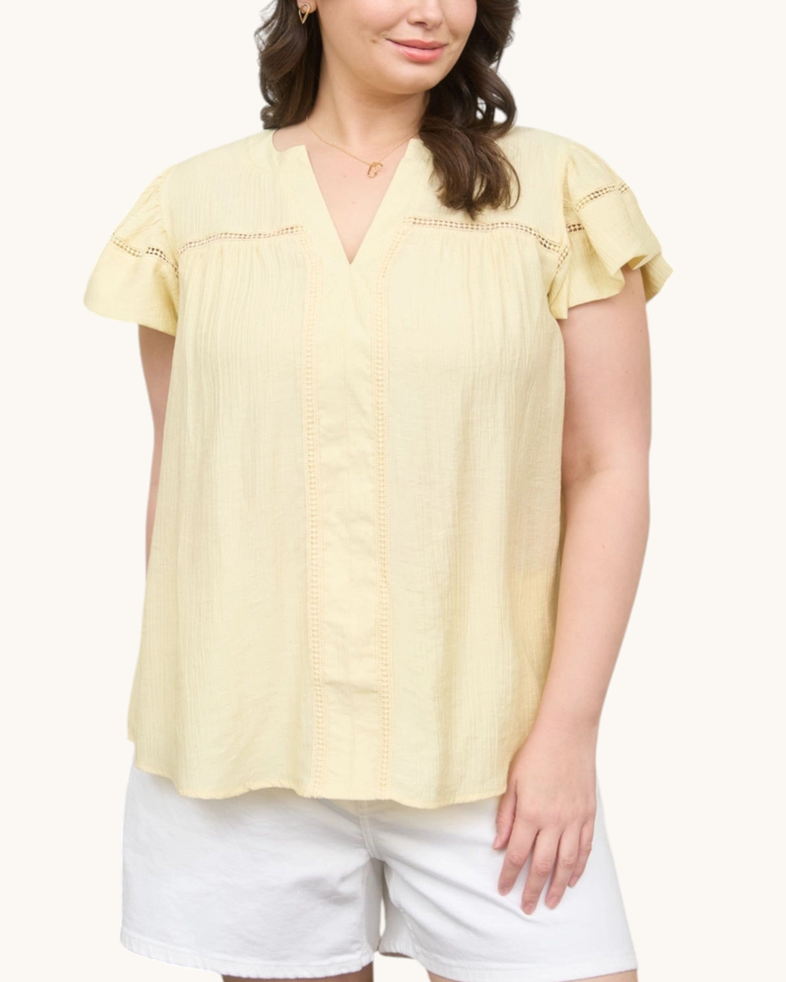 Woman wearing a Pale yellow V-neck top with ruffle sleeve, front view.