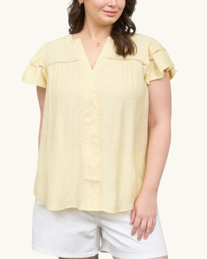 Woman wearing a Pale yellow V-neck top with ruffle sleeve, front view.