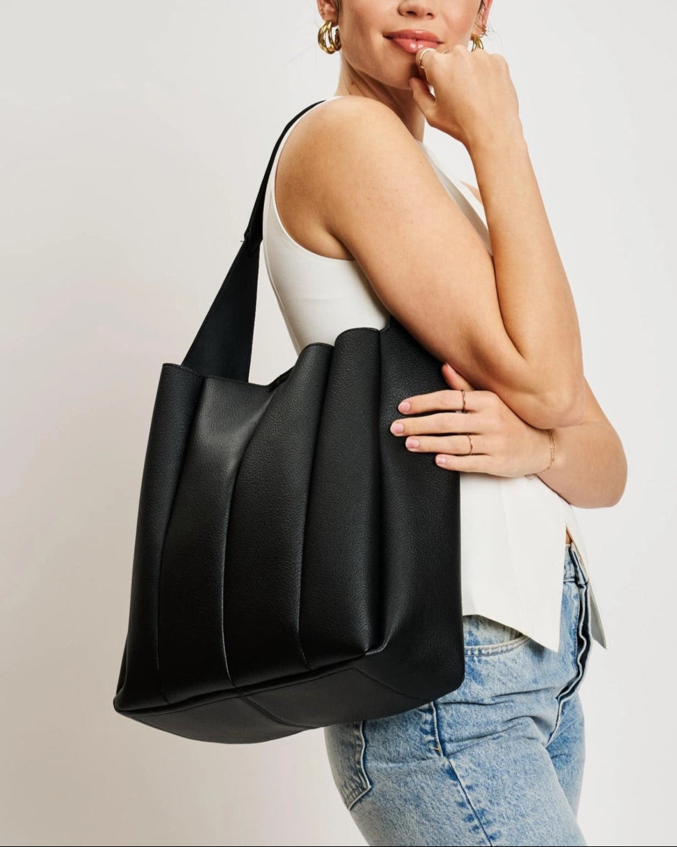 Black pleated vegan leather hobo bag with shoulder strap.
