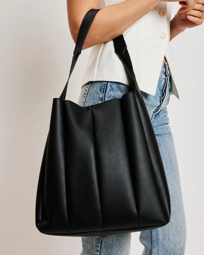 Black pleated vegan leather hobo bag with shoulder strap.