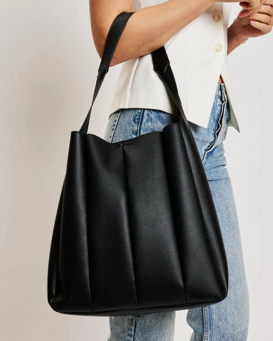Black pleated vegan leather hobo bag with shoulder strap.