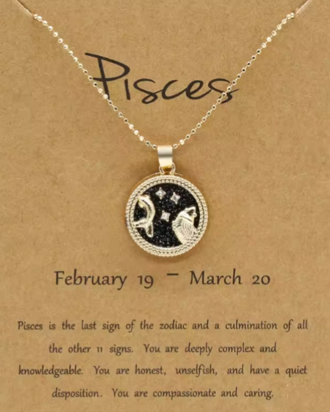 Pisces zodiac necklace on a brown card with text.