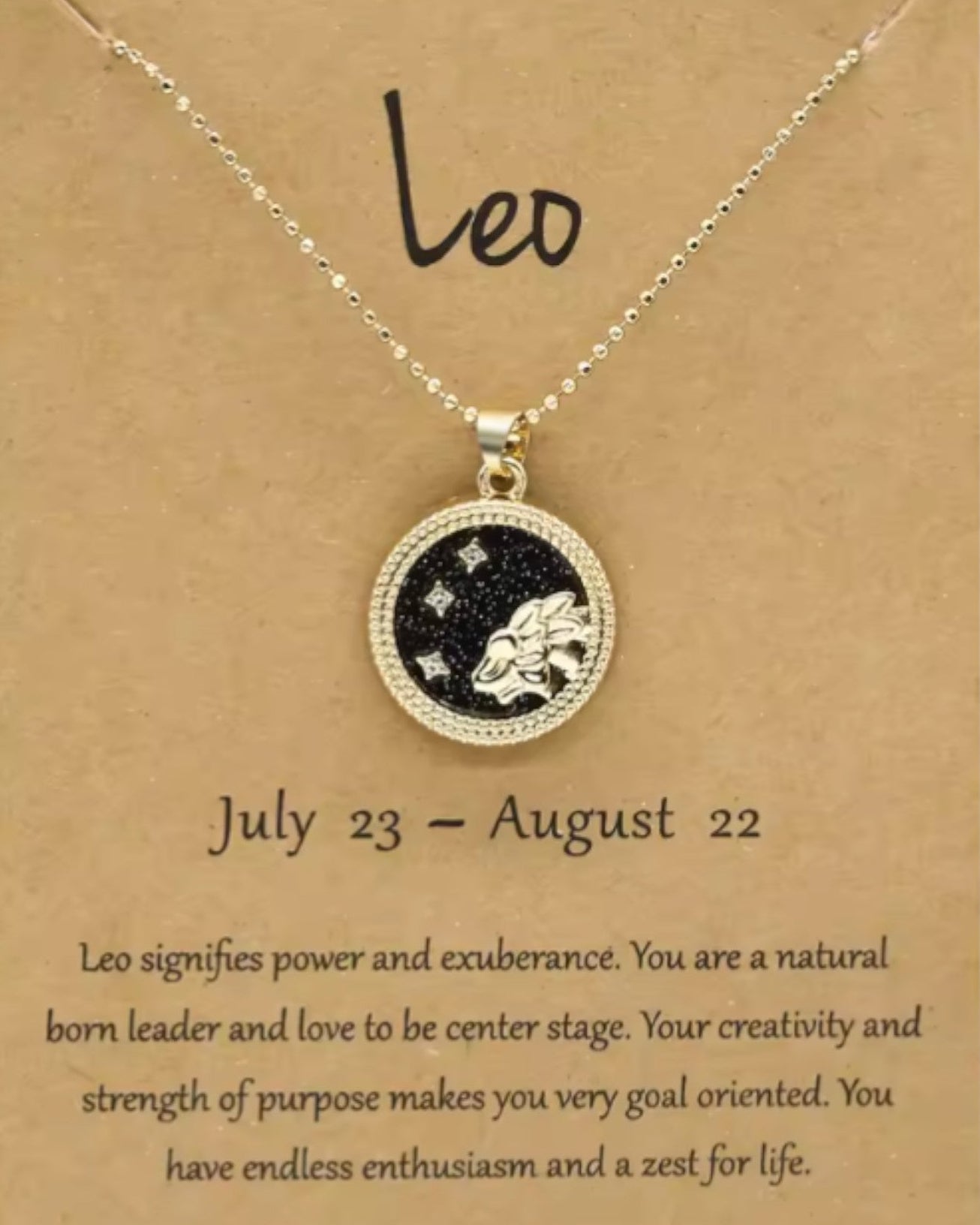 Necklace with a Leo zodiac symbol on a brown card with text about the sign.