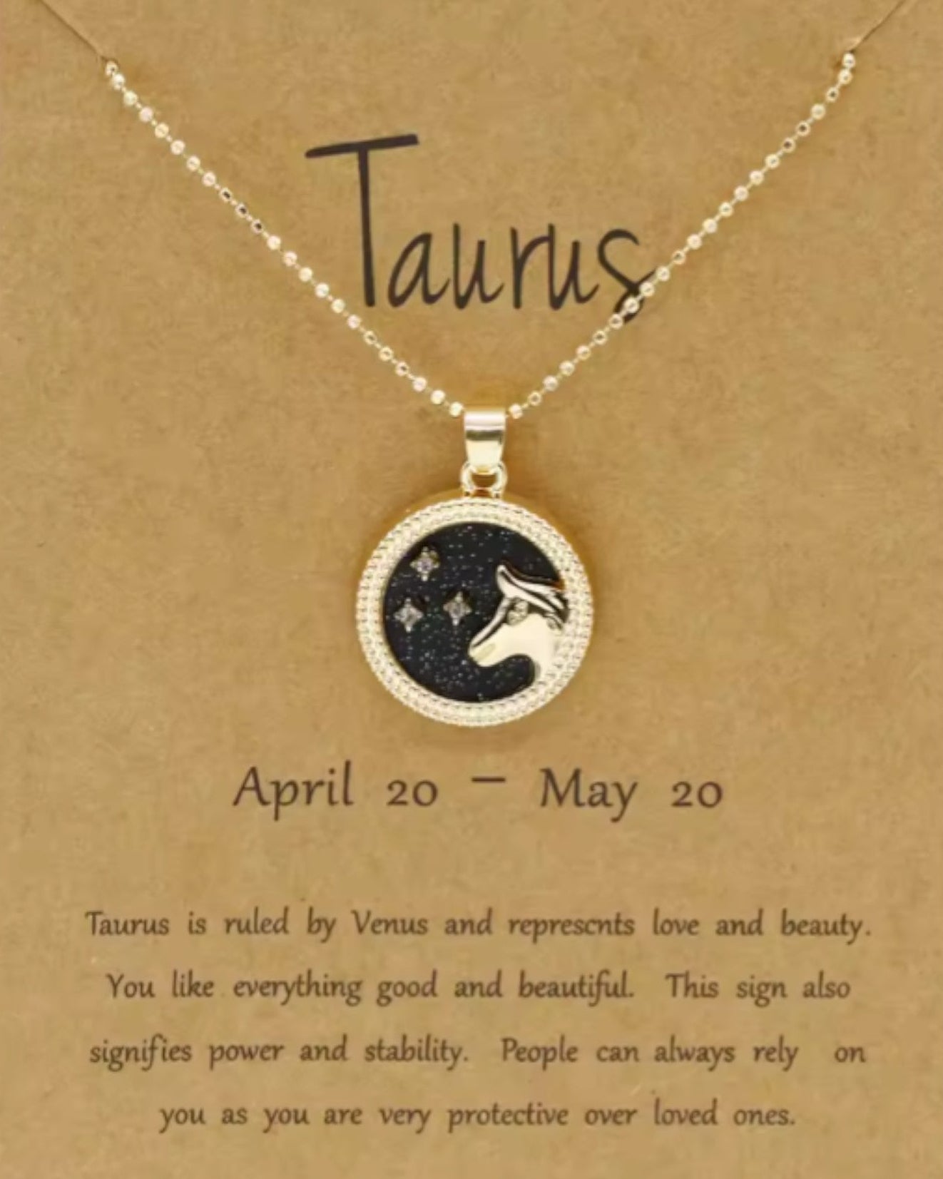 Necklace with Taurus zodiac symbol on a brown card with text.