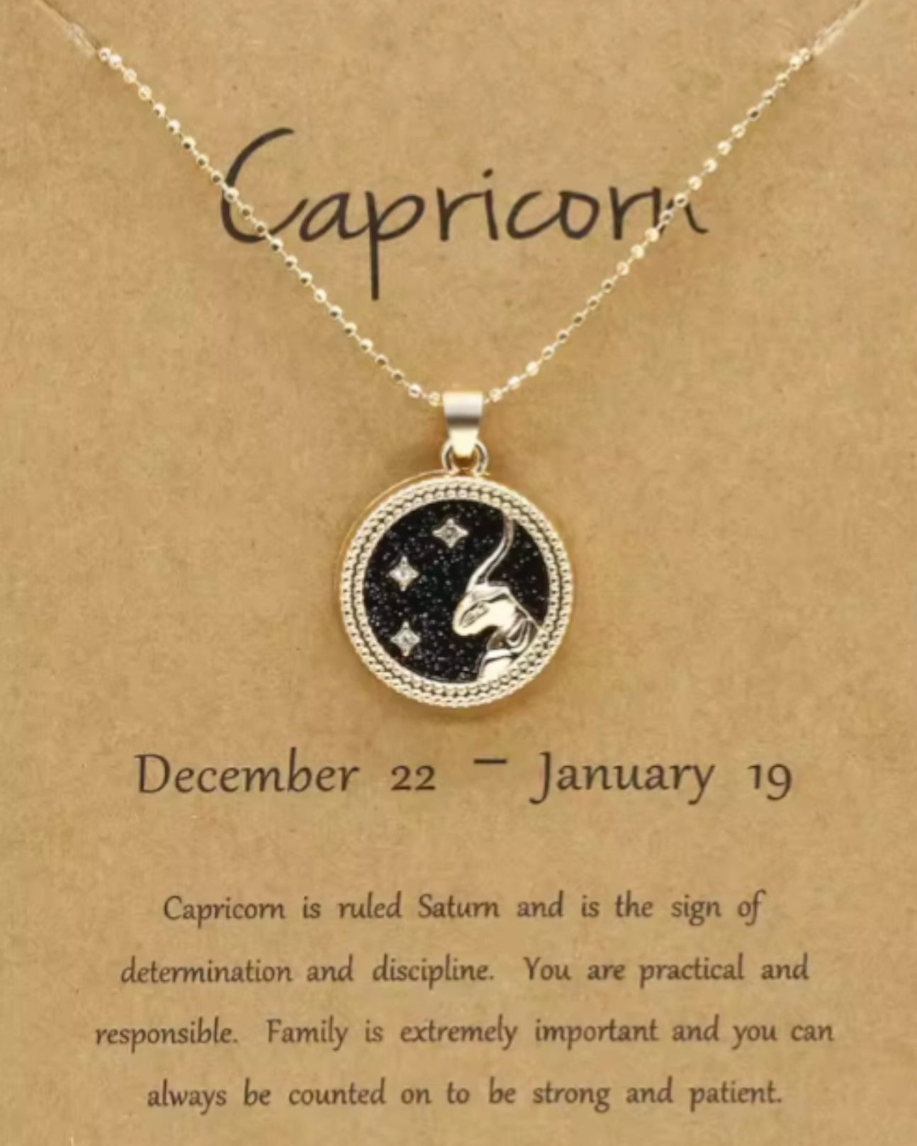 Capricorn necklace on a brown card with zodiac information.