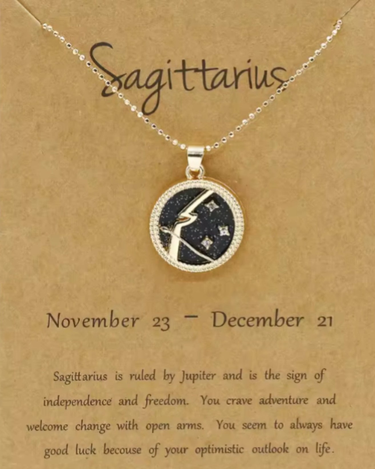 Necklace with Sagittarius zodiac sign pendant on a brown card with text.