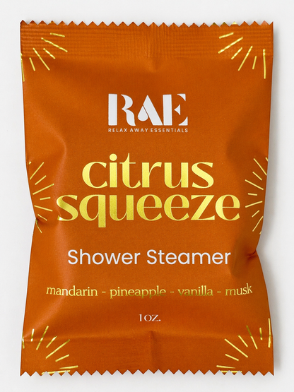 Orange shower steamer packaging with 'RAE' branding and 'citrus squeeze' text on a white background.