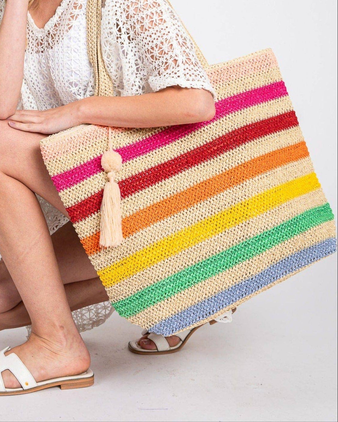 Rainbow stripe crochet beach tote bag with tassel and zipper closure.