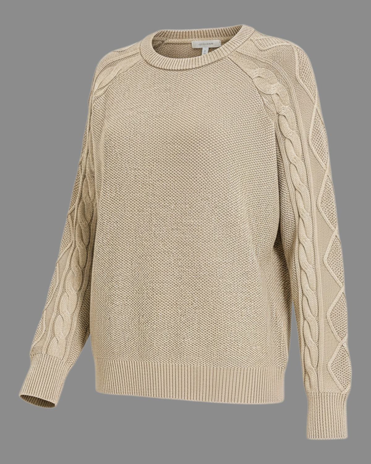 A beige cable-knit crewneck sweater with raglan sleeves, featuring textured cable patterns down the sleeves, shown against a solid gray background.