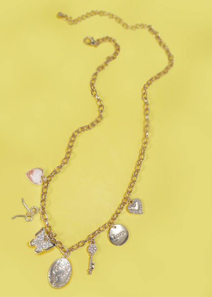 Gold charm necklace with a bow, wishbone, heart, key, butterfly, and sparkling rhinestone accents.